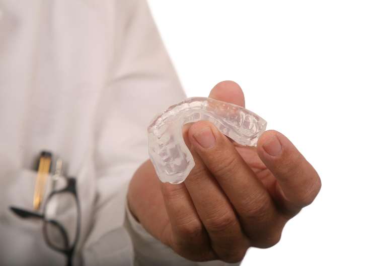 dentist holding night guard in West Chester OH