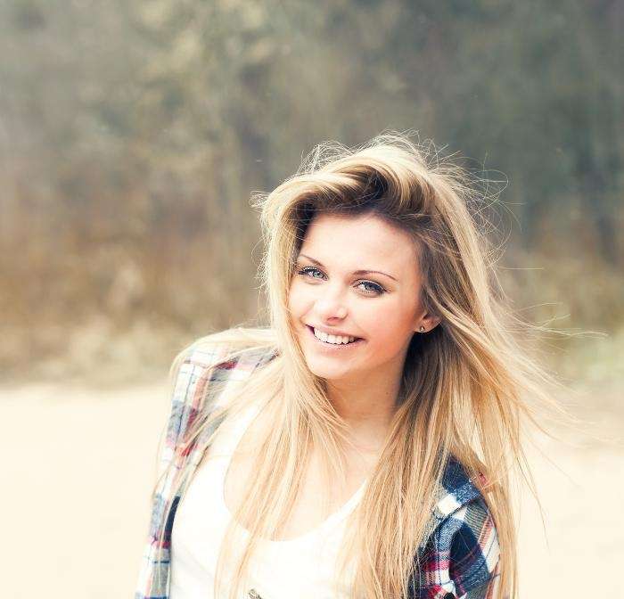 smiling blonde woman outdoors | cosmetic dentistry in West Chester OH